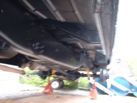 1978 Ford F-250 - The underside of a 1978 Ford F-250 is visible, supported by jack stands for maintenance.