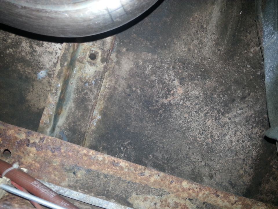 Undercarriage shot showing rust and a metal pipe
