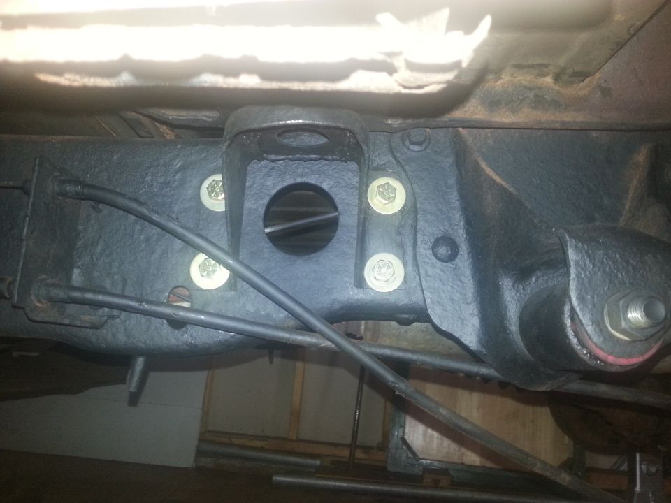 Black painted rear axle suspension bracket with bolts and brake line