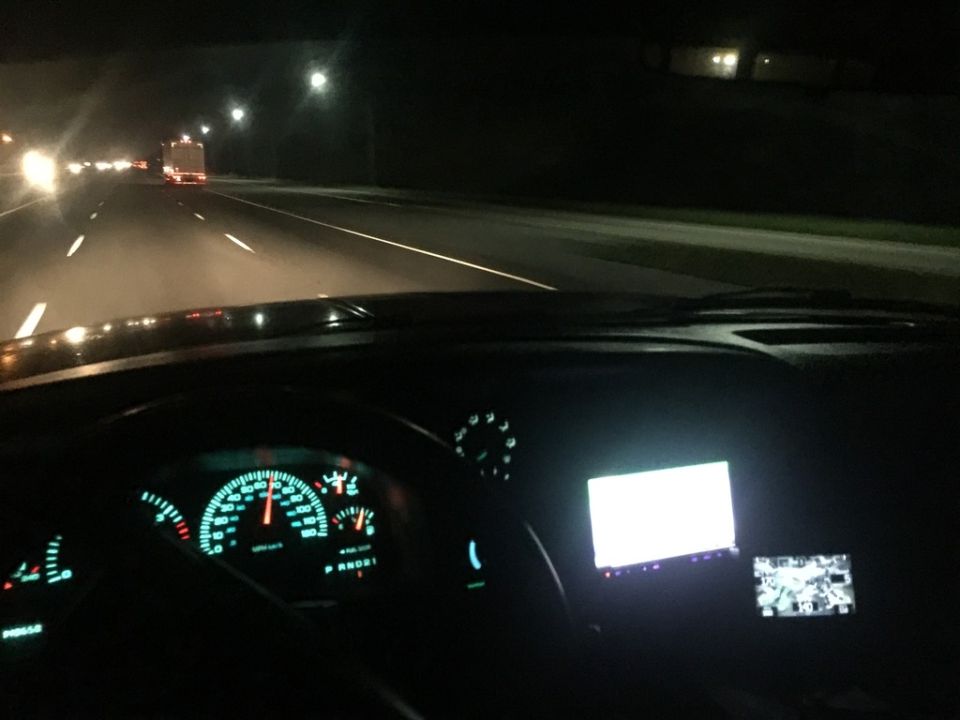 Interior view of a Dodge 2500 dashboard at night, showing illuminated gauges and a GPS screen.