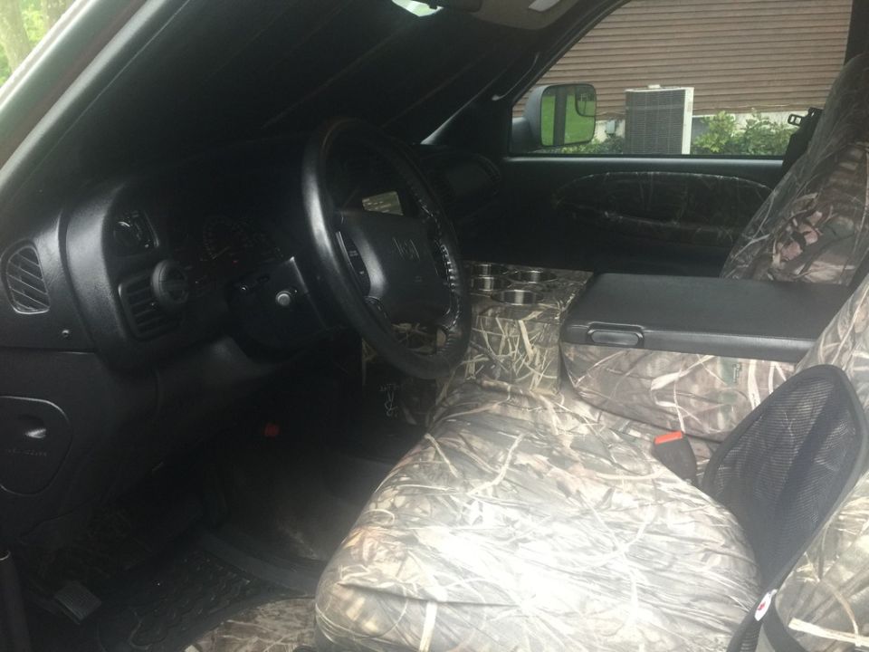 Interior of a Dodge 2500 pickup truck with camouflage seat covers.