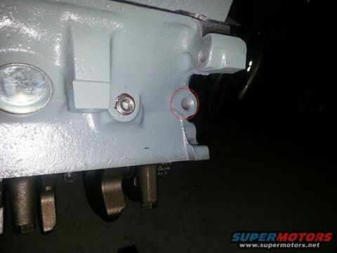 1994 Ford Bronco - Photograph of a painted engine block with a threaded hole highlighted by a red circle.
