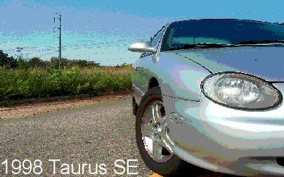 1998 Ford Taurus - Silver 1998 Ford Taurus SE captured from a low angle, showing the front quarter panel and headlight.