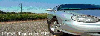 1998 Ford Taurus - A silver 1998 Ford Taurus SE is parked on a gravel road with a field and blue sky in the background.