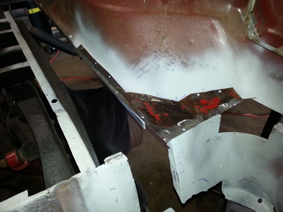 Close-up of vehicle body repair, showing metal patch being fitted.