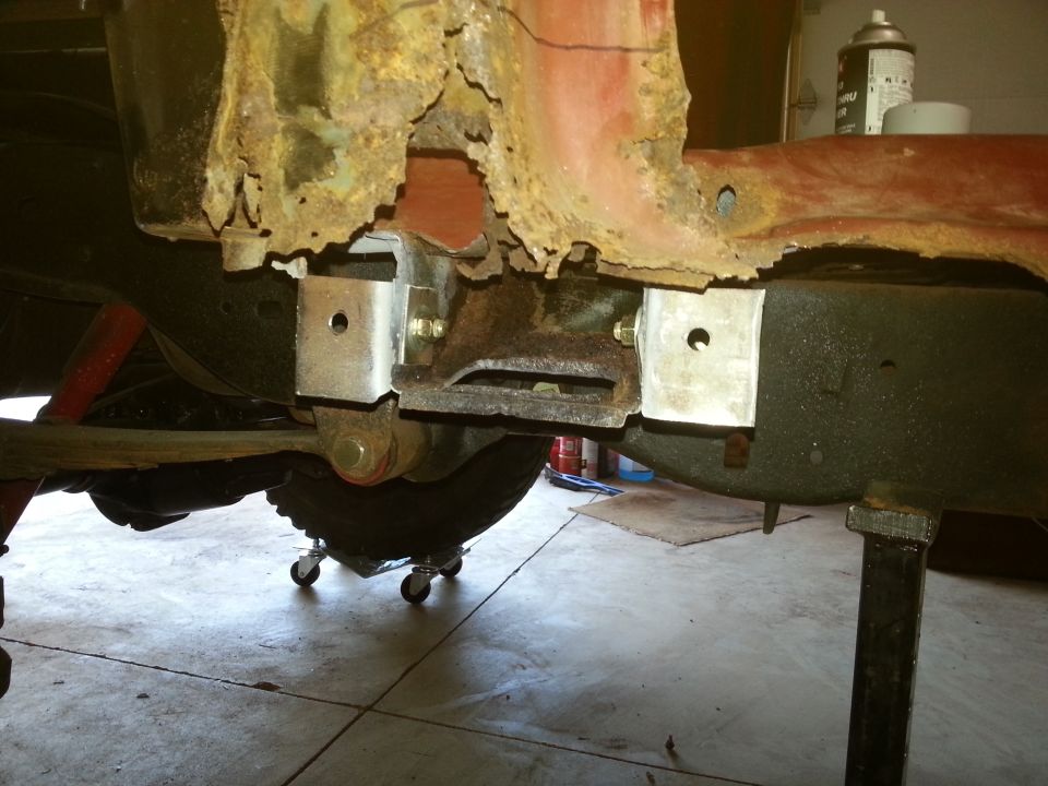 Heavily rusted Ford Bronco frame with new metal brackets installed.