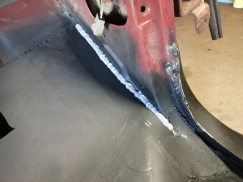 Close-up of a fresh weld on the interior of a vehicle's body.