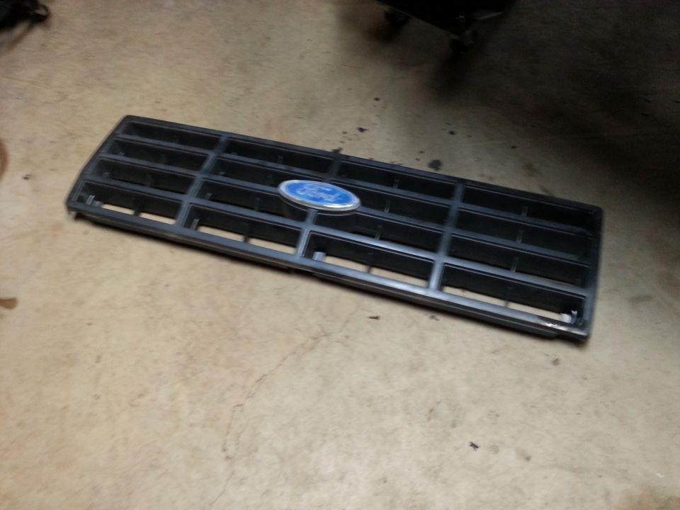 Black Ford Bronco grille with blue Ford emblem on concrete floor