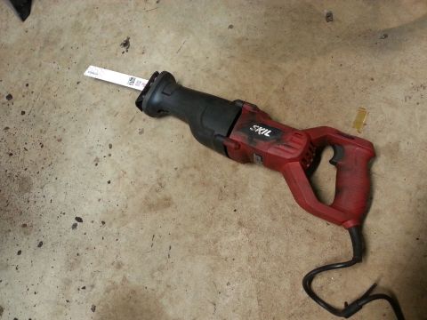 Red and black Skil reciprocating saw on a concrete floor
