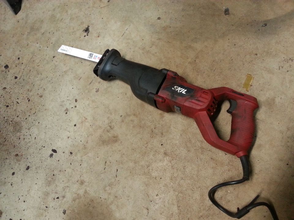Red and black Skil reciprocating saw on a concrete floor