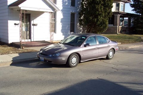 1996 Ford Taurus - This 1996 Ford Taurus is parked on a residential street next to a house.