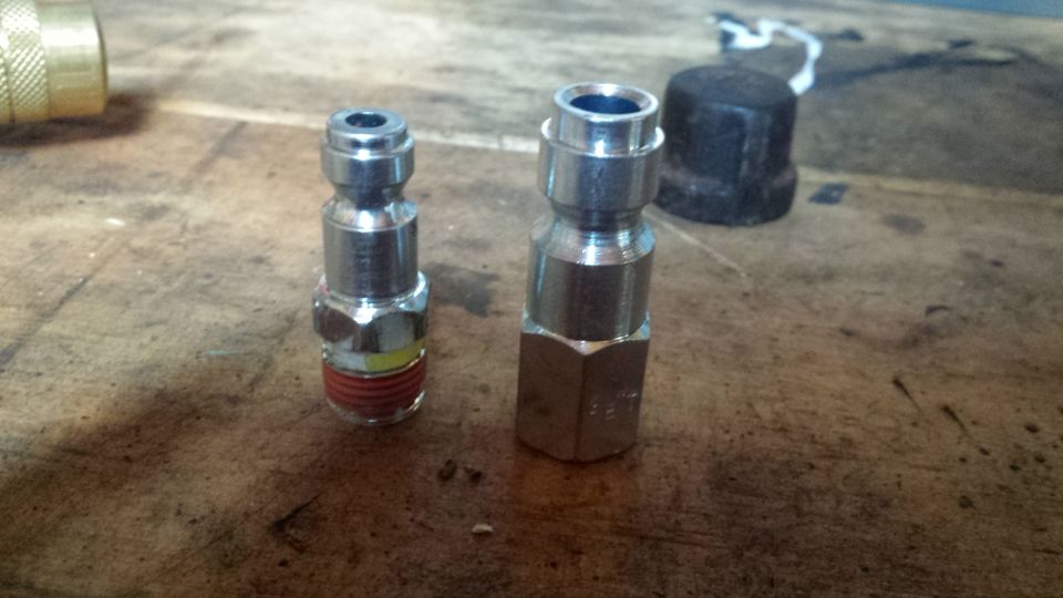Two quick-connect fittings on a wooden surface