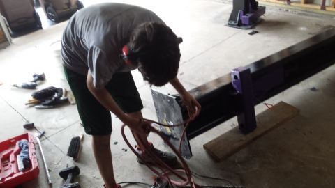 Person working on a car lift with tools on the floor