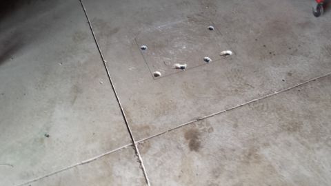 Metal plate with holes in concrete floor