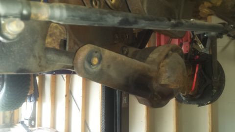 Underside of vehicle rear axle, driveshaft U-joint, and brake assembly