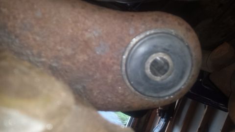 Rusted suspension part with black rubber bushing