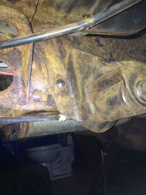 Rusted suspension part with a toilet visible underneath