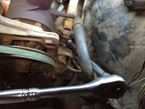 Engine bay with socket wrench on bolt. Supermotors.net logo visible