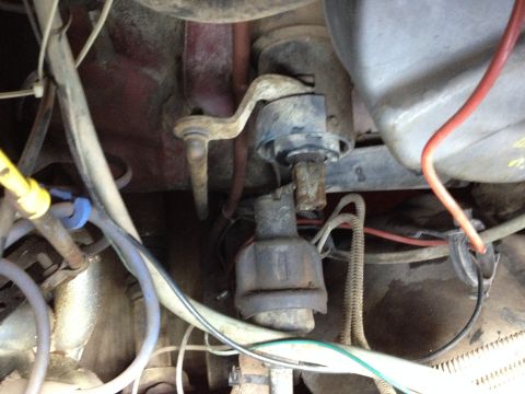 Close-up of engine bay showing distributor, wiring, and various metal parts