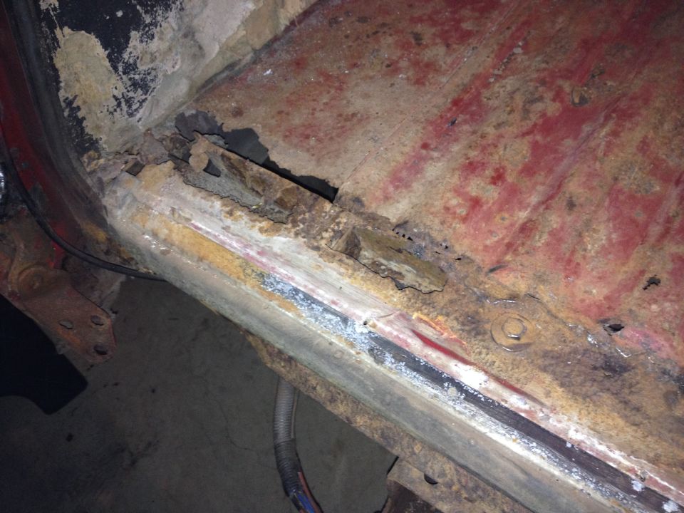 rusted metal frame of a vehicle with visible corrosion and damage