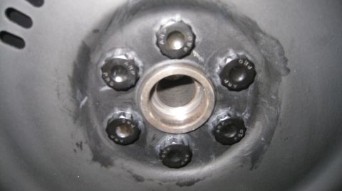1996 Ford Bronco - Close-up view of the hub of a vehicle, showing six black lug nuts with "ARP PRO" text around a central silver metal ring. The lug nuts are…