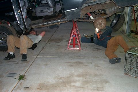 1996 Ford Bronco - Keith up front taking off the front driveshaft so we can swap yokes to the new D44. Scott in back removing the rear DS