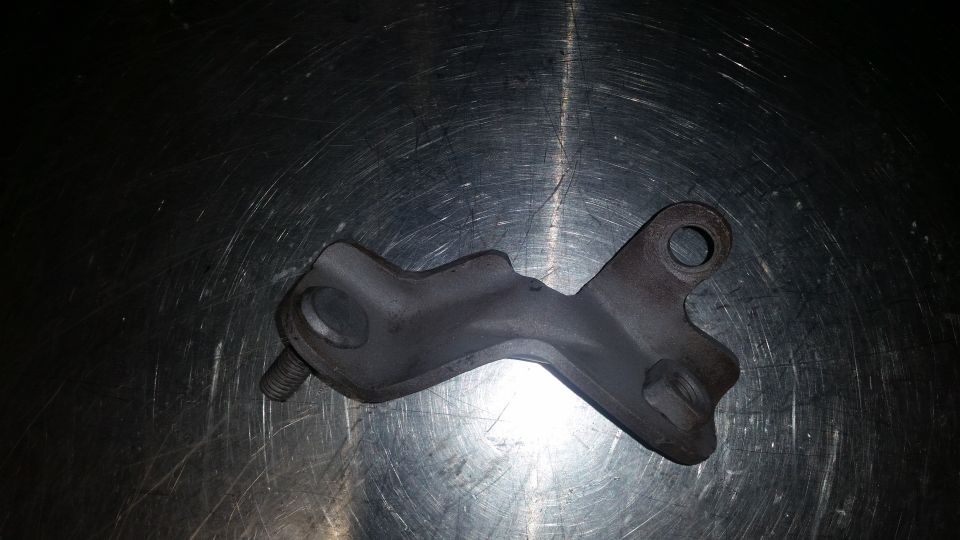 Metal bracket with bolt on scratched metal surface