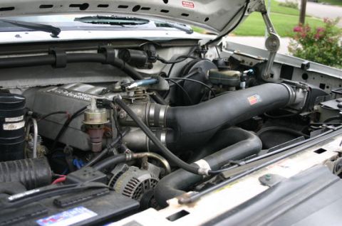 1996 Ford Bronco - The engine bay of a 1996 Ford Bronco shows a modified intake system with a K&N air filter and a large black intake tube. Various engine com…