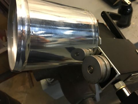 1996 Ford Bronco - A close-up view of a shiny, cylindrical metal part attached to a black mechanical device. Two metallic rollers are visible beneath the cyli…