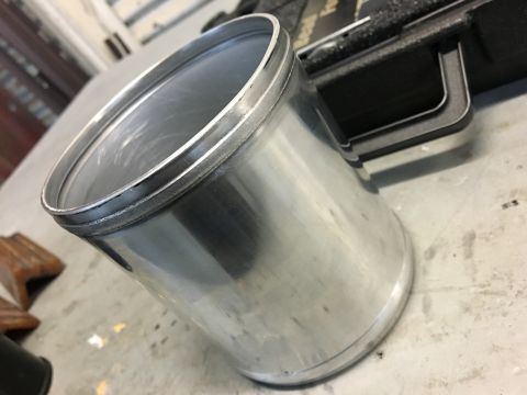 1996 Ford Bronco - A close-up view of a shiny metal cylinder with a handle attached to a black case in the background.