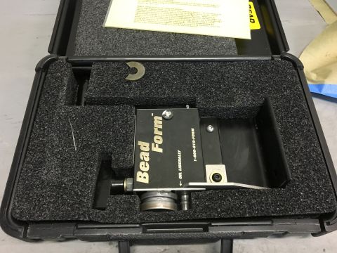 1996 Ford Bronco - A black plastic case with foam padding holds a "Bead Form" tool. The tool has text that reads "OIL LIBERALLY" and a phone number "1-800-919…