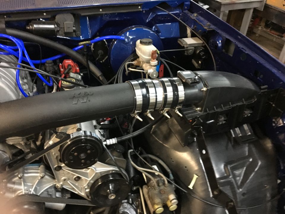 Engine bay with K&N intake, supercharger, and blue spark plug wires.