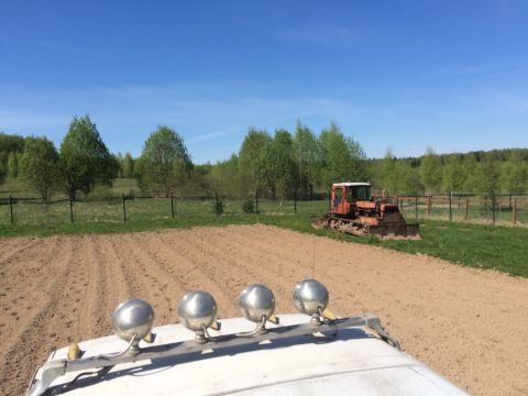 1993 Ford Bronco - A view from the roof of a vehicle shows a plowed field in the foreground and a rusty orange tractor parked on a grassy area in the backgrou…