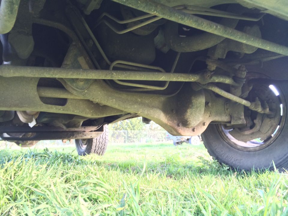 Underside of a 1993 Ford Bronco showing rear differential, suspension, and tire.