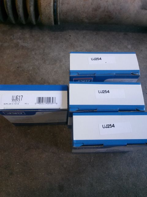 1996 Ford Bronco - Four boxes of automotive parts are laid out on a concrete surface. Three boxes are labeled "UJ254" and one box is labeled "UJ617" with a ba…