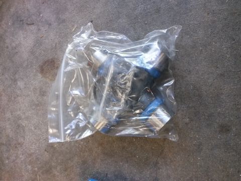 1996 Ford Bronco - A clear plastic bag containing several automotive parts, possibly fuel injectors, lies on a concrete surface.