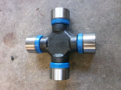 1996 Ford Bronco - A universal joint with blue seals is shown lying on a concrete surface.