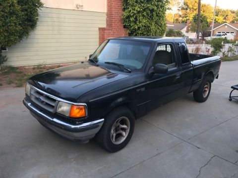 1986 Ford Bronco - This black Ford Ranger pickup truck is shown from a 3/4 front angle.