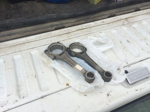 1993 Ford Bronco - Connecting rods are laid out on plastic sheeting inside a truck bed.