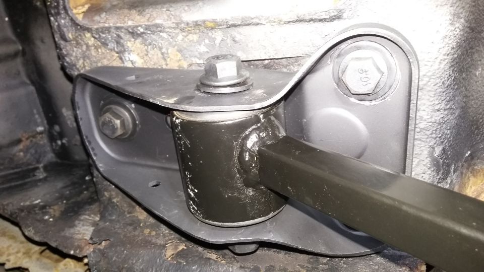 close-up of a car's suspension component with bolts and metal brackets