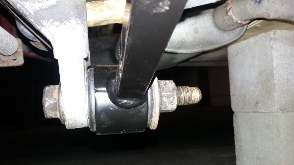 Close-up of a black suspension bushing and bolt on a vehicle's undercarriage