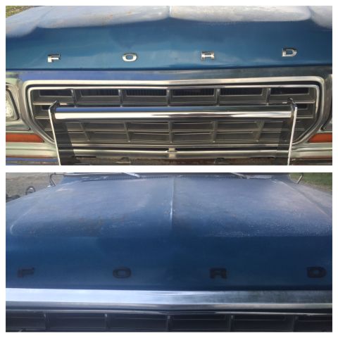 1979 Ford Bronco - Close-up of the front grille and hood of a blue 1979 Ford Bronco, showing the 'FORD' lettering and chrome details.