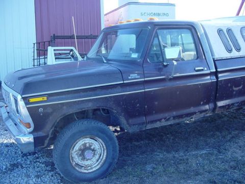 1992 Ford Bronco - This 1977 Ford F-Series truck is equipped with a camper shell and parked outdoors.