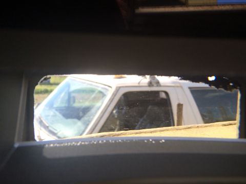 1993 Ford Bronco - A white SUV is seen through a damaged opening in another vehicle's interior.
