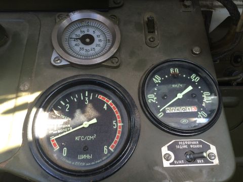 1993 Ford Bronco - Close-up of a vehicle's interior dashboard, showing various analog gauges and a toggle switch.