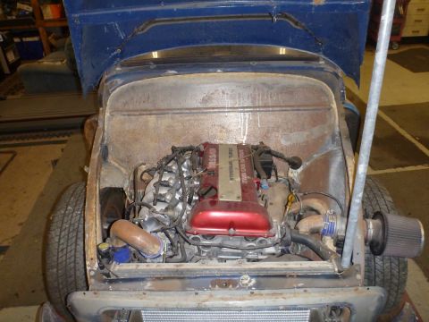 1969 MINI Cooper - Custom engine swap in a classic vehicle, a red turbo engine and exposed piping.