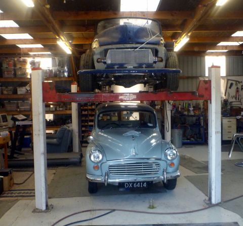 1969 MINI Cooper - Two classic cars are parked in a garage, one is on a lift.