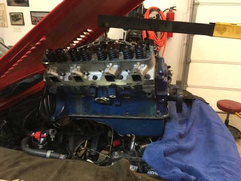 1968 Shelby GT500 - Engine assembly is underway with the hood open and a hoist supporting the motor.