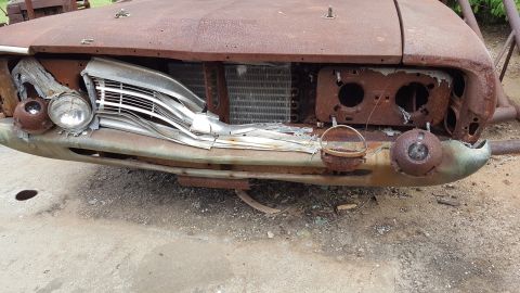 1973 Ford F-100 - Front view of a heavily rusted 1973 Ford F-100 showing damage to the grille and headlight assembly.