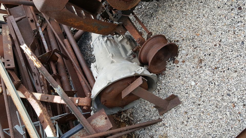 transmission and rusty metal parts piled on gravel